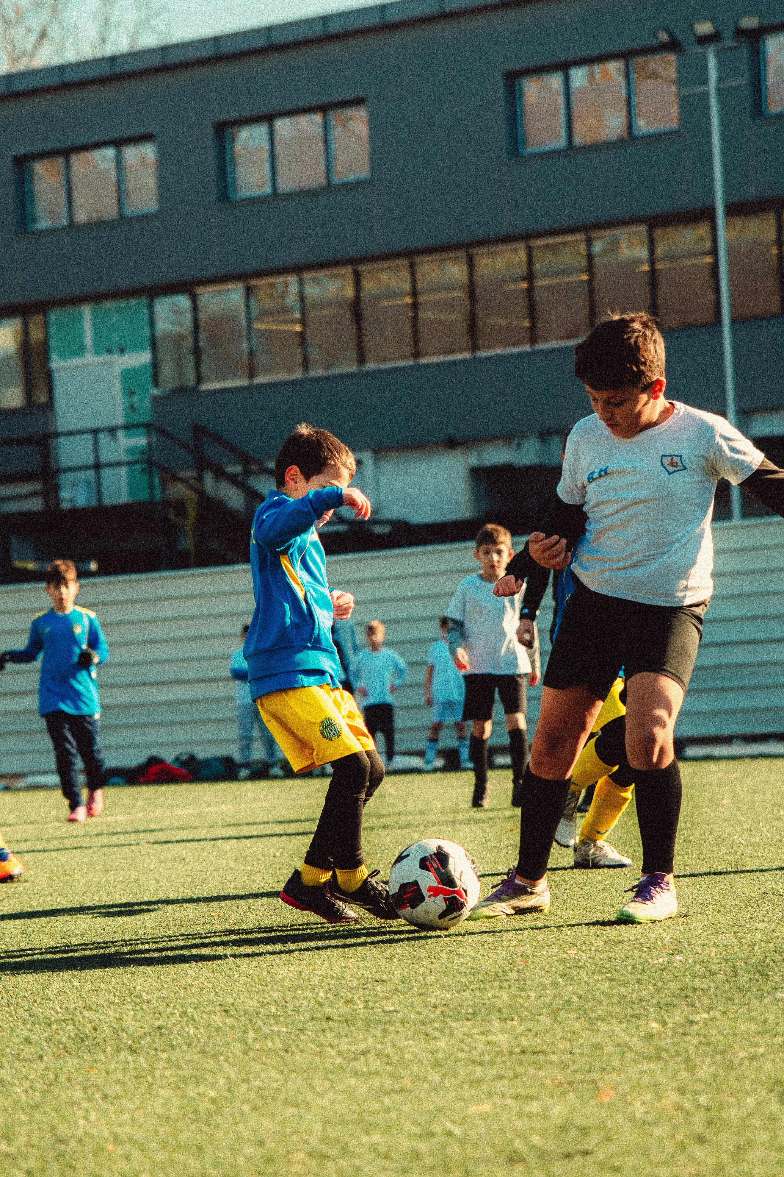 Two kids competing for the ball in a youth soccer match